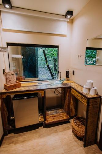 a bathroom with a counter with a glass sink at Bossa Beach House in Ilha do Mel