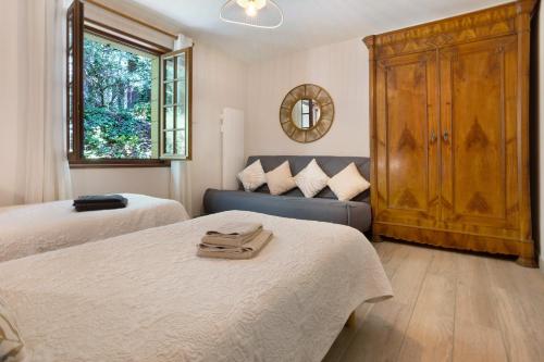 a bedroom with two beds and a blue couch at Gite Chante' Alouette – Le Bugue in Le Bugue