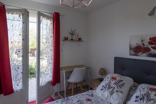 a bedroom with a bed and a desk and a window at chambre d'hotes les cigales in Comps