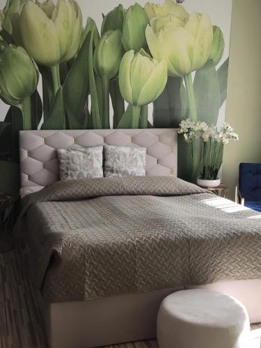 a bedroom with a large bed with flowers on the wall at Kate Sea Apartment in Pärnu