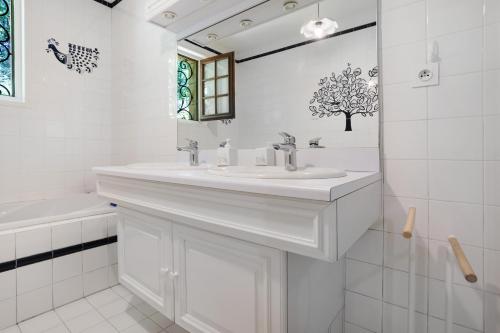 a white bathroom with a sink and a tub at Gite Chante' Alouette – Le Bugue in Le Bugue