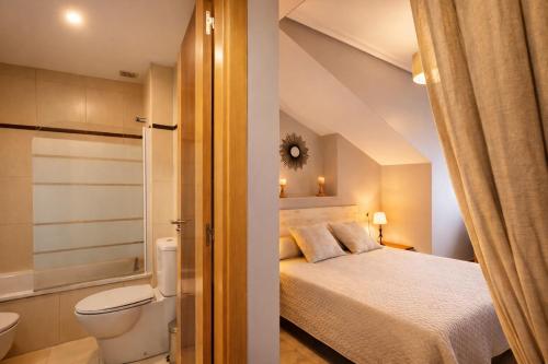 a bedroom with a bed and a bathroom with a toilet at Apartamento turístico Aldamar in Llanes