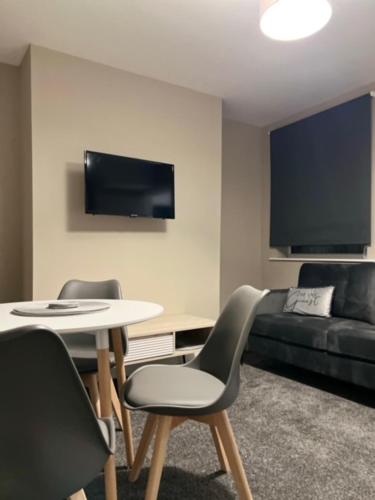 a living room with a table and chairs and a couch at Room in Melrose Shared House in Hull