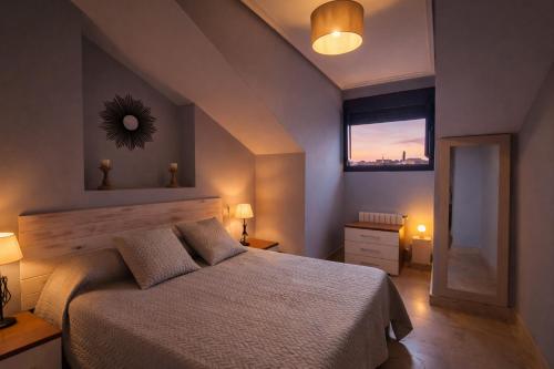 a bedroom with a bed and a window and a mirror at Apartamento turístico Aldamar in Llanes