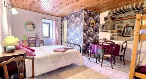 a bedroom with a bed and a table and chairs at Chambre d'hôtes L'Adrienne in Chazeaux