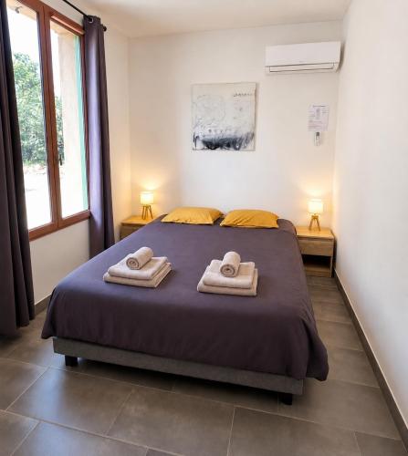 a bedroom with a bed with two towels on it at Gîte du salagou in Octon