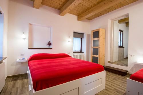a bedroom with white walls and a red bed at Agriturismo Amargi in Smerillo
