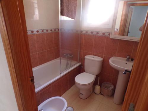 a bathroom with a toilet and a tub and a sink at Camposol House in Mazarrón