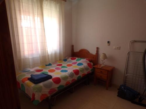 a small bedroom with a bed and a window at Camposol House in Mazarrón