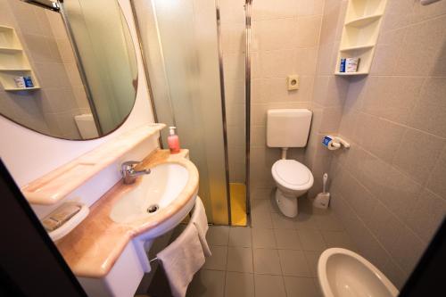 a bathroom with a sink and a toilet and a mirror at Hotel Madison - Cattolica in Cattolica