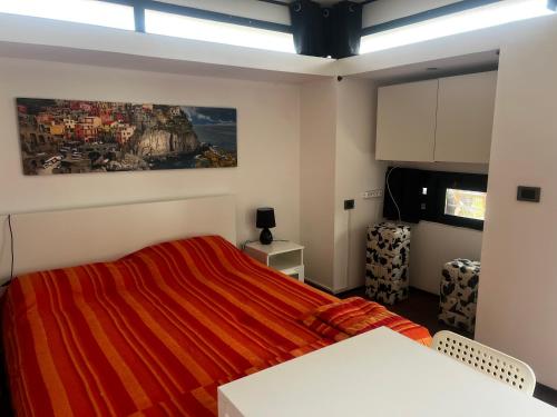 a bedroom with a red bed with a painting on the wall at Studio Natalie in Marina di Massa