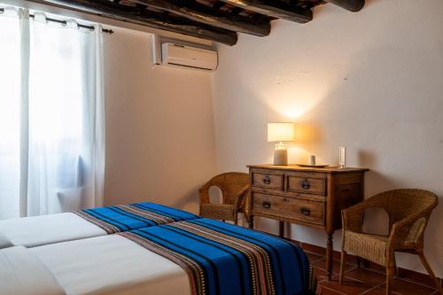 a bedroom with a bed and a dresser and a window at Dom Nuno by Horta da Moura in Monsaraz