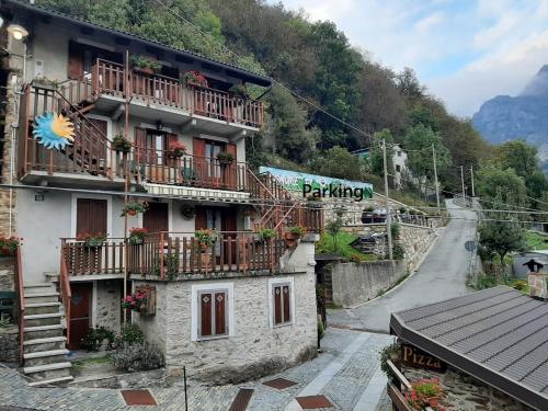 a building with balconies and flowers on a mountain at Nido Paradiso Nido, Balcone panoramico sulla Valle Soana in Ingria