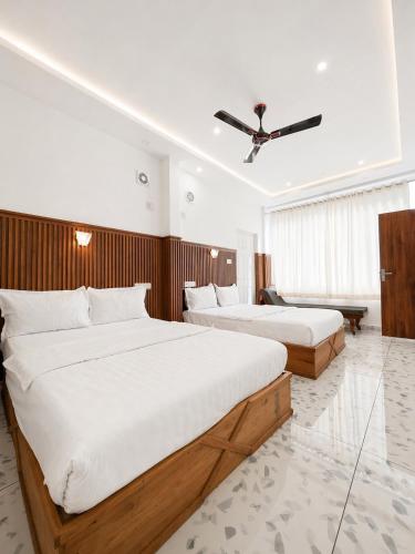 a hotel room with two beds and a ceiling at Real Casa in Anachal