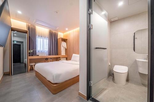 a hotel room with a bed and a bathroom at Giverny Hotel in Gyeongju