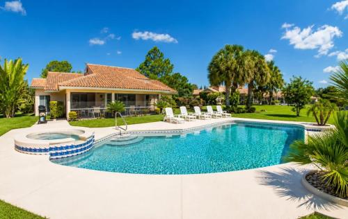 a swimming pool with chairs and a house at SWISS 61 - Lake Denise in Clermont