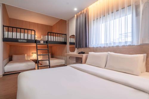 a bedroom with a bed and two bunk beds at Giverny Hotel in Gyeongju