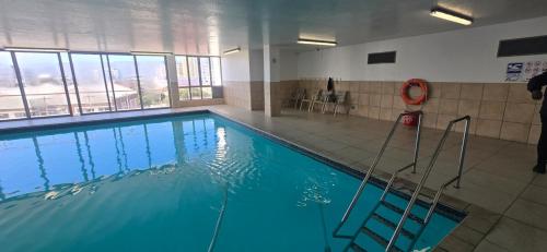 a large swimming pool with blue water in a building at Hibernian Towers 307 in Strand