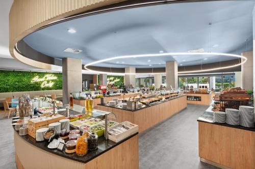 a restaurant with a buffet line with food at Park Inn by Radisson Sarvar Resort & Spa - All Inclusive in Sárvár