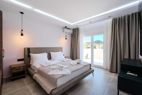 a bedroom with a bed and a large window at Orizon Apartments in Limenas