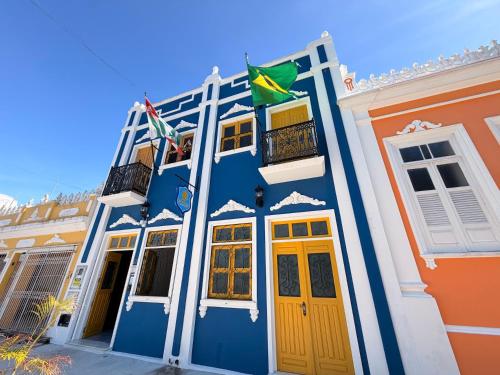 a blue building with two flags in front of it at Imperialis Boutique Hotel in Canavieiras