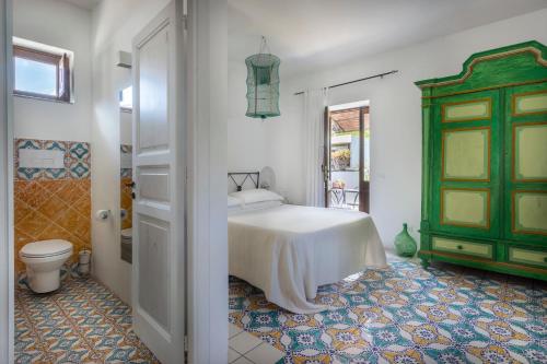 a bedroom with a bed and a green door at Boutique Hotel I Cinque Balconi in Santa Marina Salina