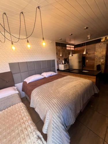 a bedroom with two beds and a kitchen at Quarto Aconchegante N 3 in Rio Negro