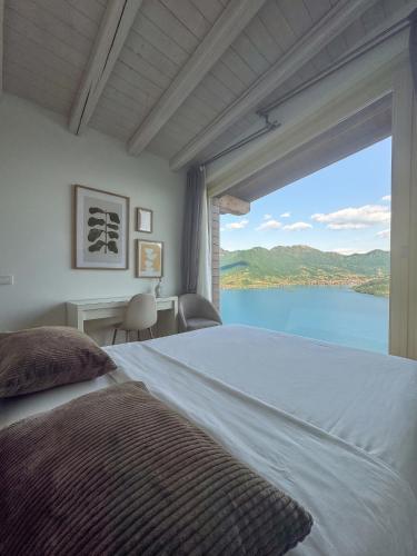 a bedroom with a large bed and a large window at Le Sirene in Parzanica