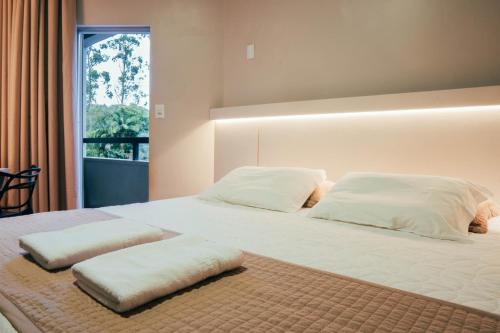 a bedroom with two beds with white pillows and a window at Real NOB Hotel in Orleans