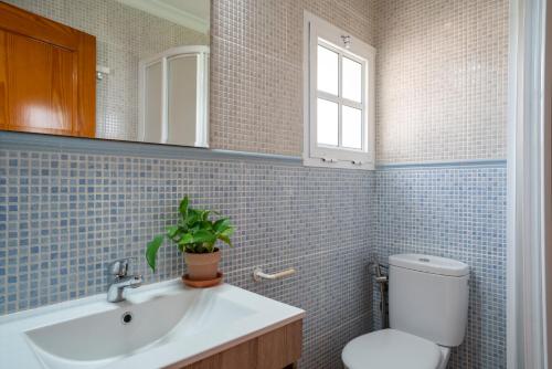 a bathroom with a sink and a toilet and a window at La Huertina C2 in Zahora