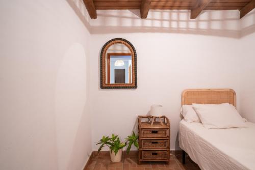 a bedroom with a bed and a mirror on the wall at La Huertina C2 in Zahora