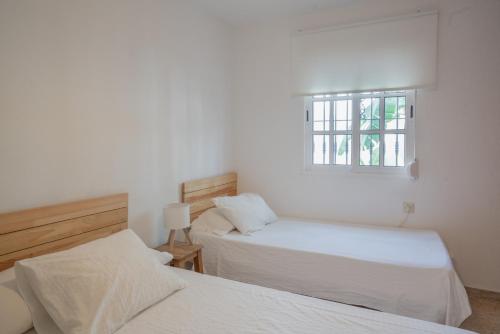 a bedroom with two beds and a window at La Huertina C1 in Zahora
