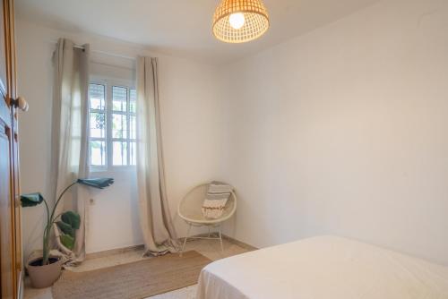 a bedroom with a bed and a chair and a lamp at La Huertina C1 in Zahora
