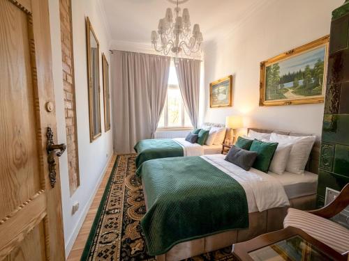 a hotel room with two beds and a chandelier at Belle Époque Sopot in Sopot