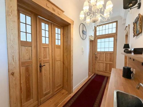 a kitchen with a wooden door and a chandelier at Belle Époque Sopot in Sopot