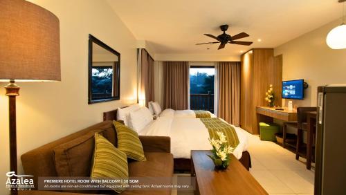 a hotel room with a bed and a couch at Azalea Residences Baguio in Baguio