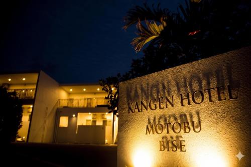 a hotel sign in front of a building at night at 還元ホテル 本部備瀬 in Motobu