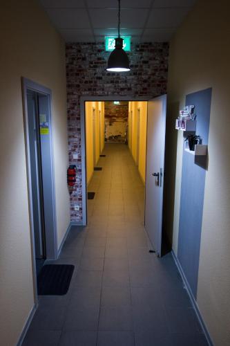 a long hallway with yellow walls and a hallway with a hallwayngth at Hostel Gästehaus Kaiserpassage- Ihr Cityhostel in Karlsruhe