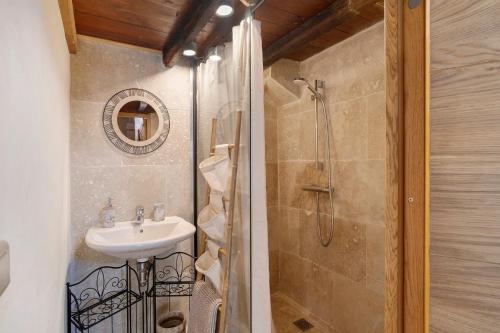 a bathroom with a sink and a shower at Maison Les Rocailles in Saint-Martin-des-Combes