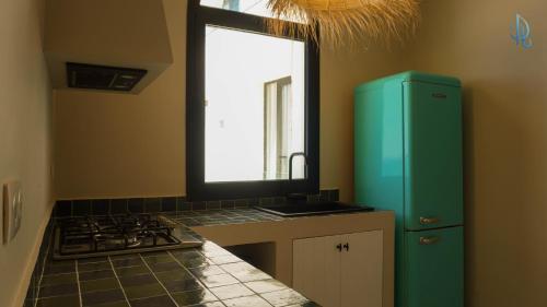 a kitchen with a green refrigerator and a stove at Diar Ayoub in Chebba