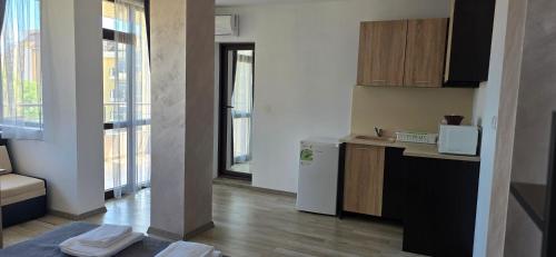 a small kitchen with a refrigerator and a microwave at Casa Del Mar in Primorsko