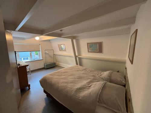a bedroom with a bed in the corner of a room at Hotel B&B Altijd Wad in West-Terschelling