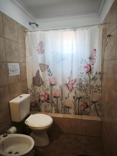 a bathroom with a toilet and a shower curtain with butterflies at Tesoro Escondido in Santa Rosa