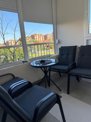 a room with two chairs and a table and two windows at Maribelle Apartments in Kruševac