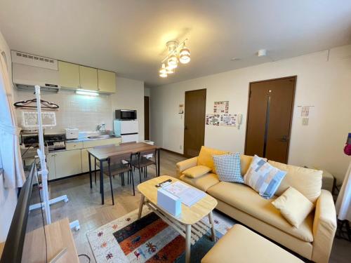 a living room with a couch and a table at Transys three in Chitose