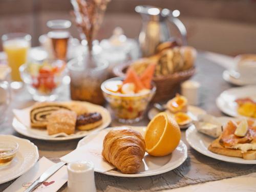 a table topped with plates of pastries and orange slices at Genuss - und Vitalhotel Moisl in Abtenau