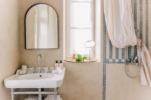 a bathroom with a sink and a mirror and a shower at Les Bassans - Fontenille Collection in Perros-Guirec