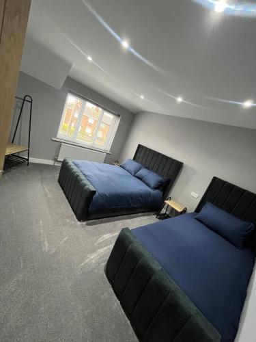 a bedroom with two beds and a couch at Droversdale Delux hottub and pool table in Bircotes