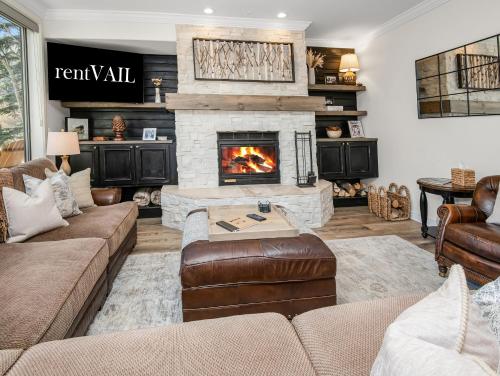 a living room with a fireplace and a couch at Highlands Slopeside in Beaver Creek