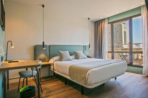 a bedroom with a bed and a table and a desk at Hotel Via Augusta in Barcelona